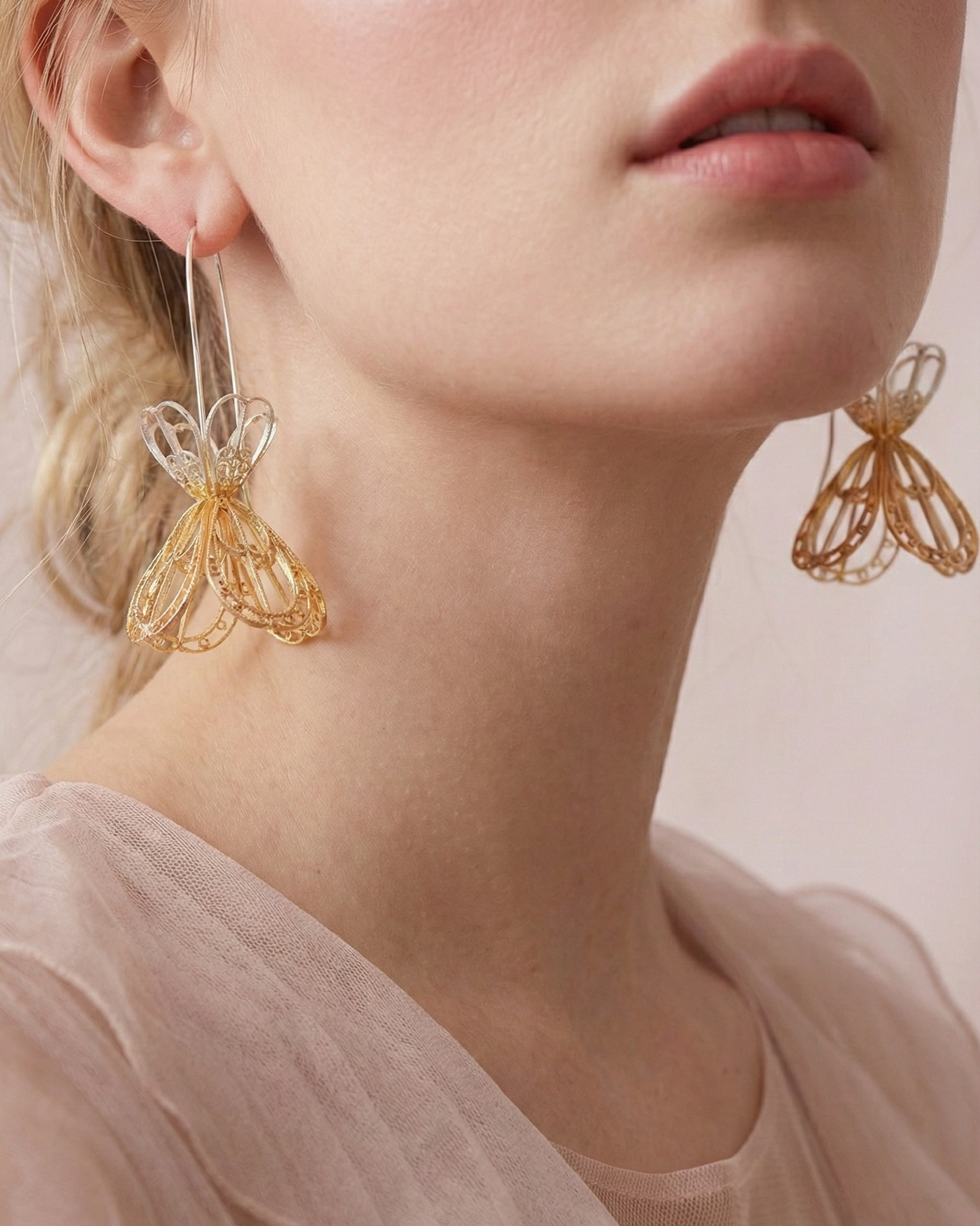 Mujer luciendo los Aretes Gancho Sombrerito de joyería Daila, destacando la caída elegante, el movimiento y la ligereza de la filigrana momposina.