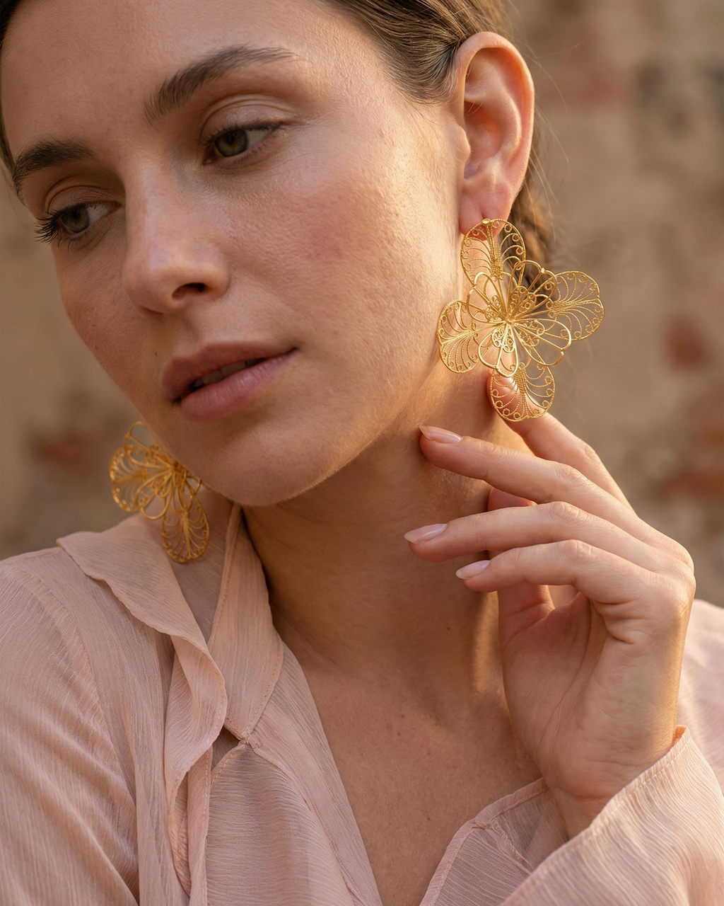 Mujer luciendo maxi aretes tipo mandala tejidos a mano en filigrana colombiana, joyería fina artesanal Daila.