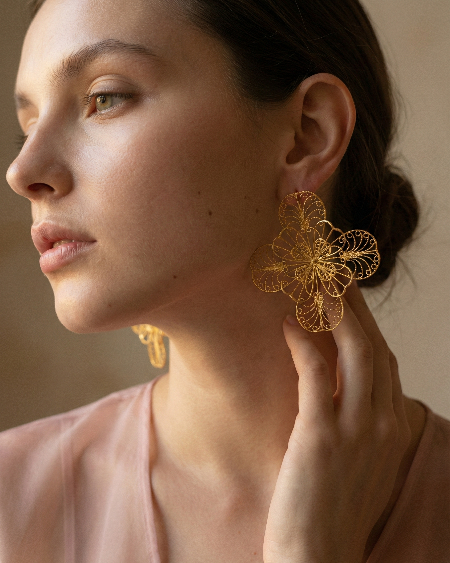 Modelo usando los Aretes Grandes Mandala en filigrana de Mompox con baño de oro, destacando su diseño aéreo y ligereza.