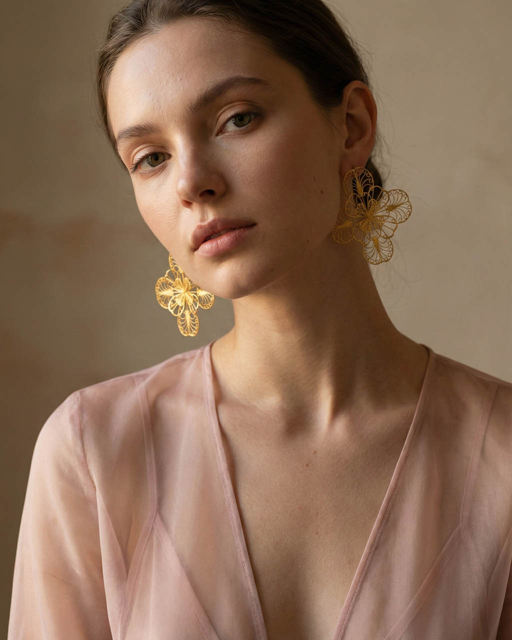 Modelo usando los Aretes Grandes Mandala en filigrana de Mompox con baño de oro, destacando su diseño aéreo y ligereza.