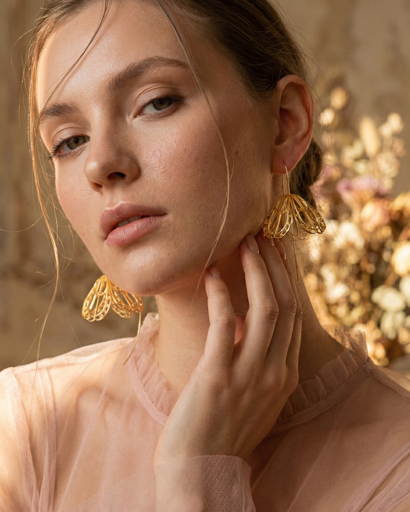 Mujer luciendo los Aretes Gancho Medio Sombrerito con baño de oro, destacando su caída elegante, ligereza y el arte de la filigrana aérea de Daila.