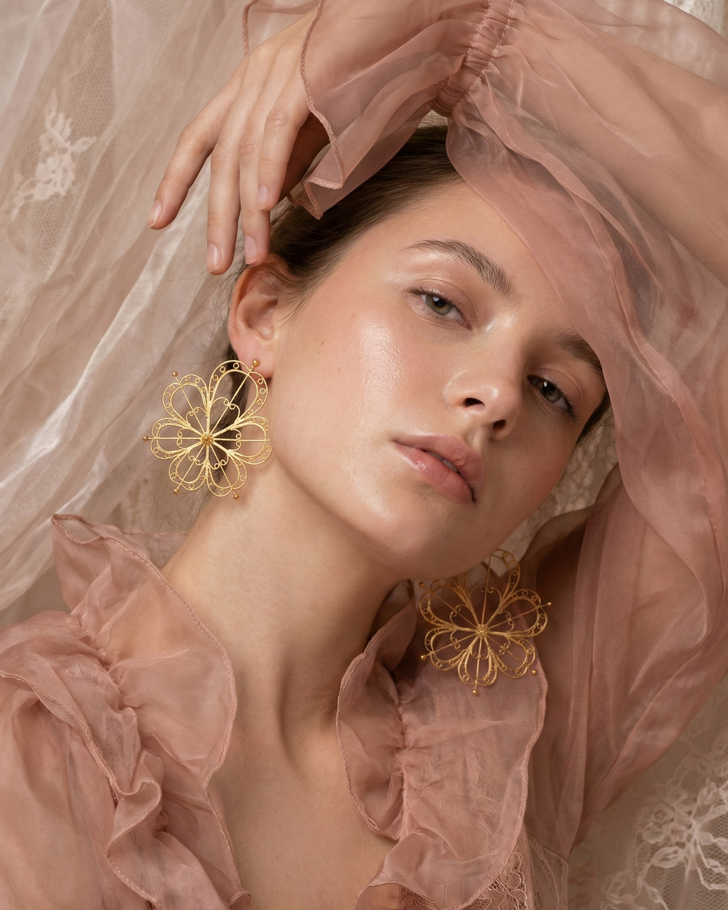 Modelo usando aretes grandes dorados 6 Corazones Mandala de DAILA.