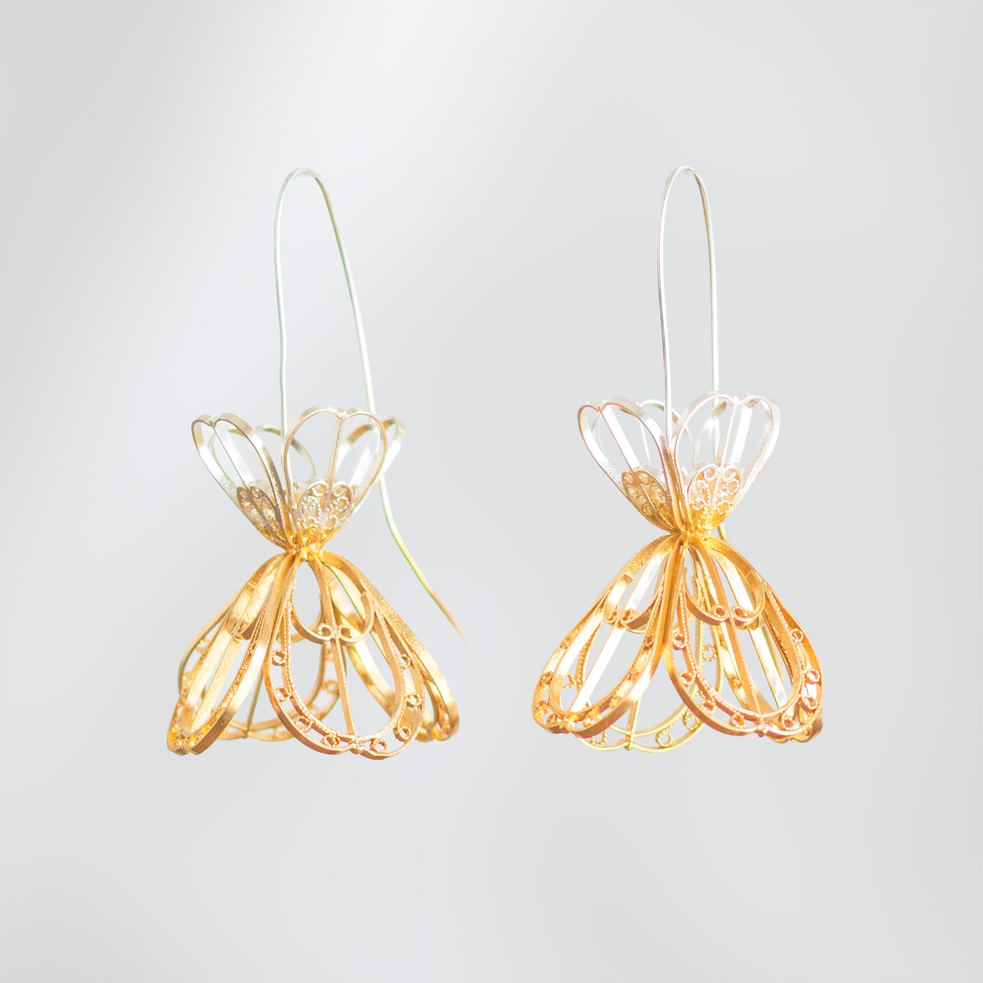 Detalle de los Aretes Gancho Sombrerito, diseño colgante con volumen tridimensional tejido a mano en filigrana de plata y baño de oro.
