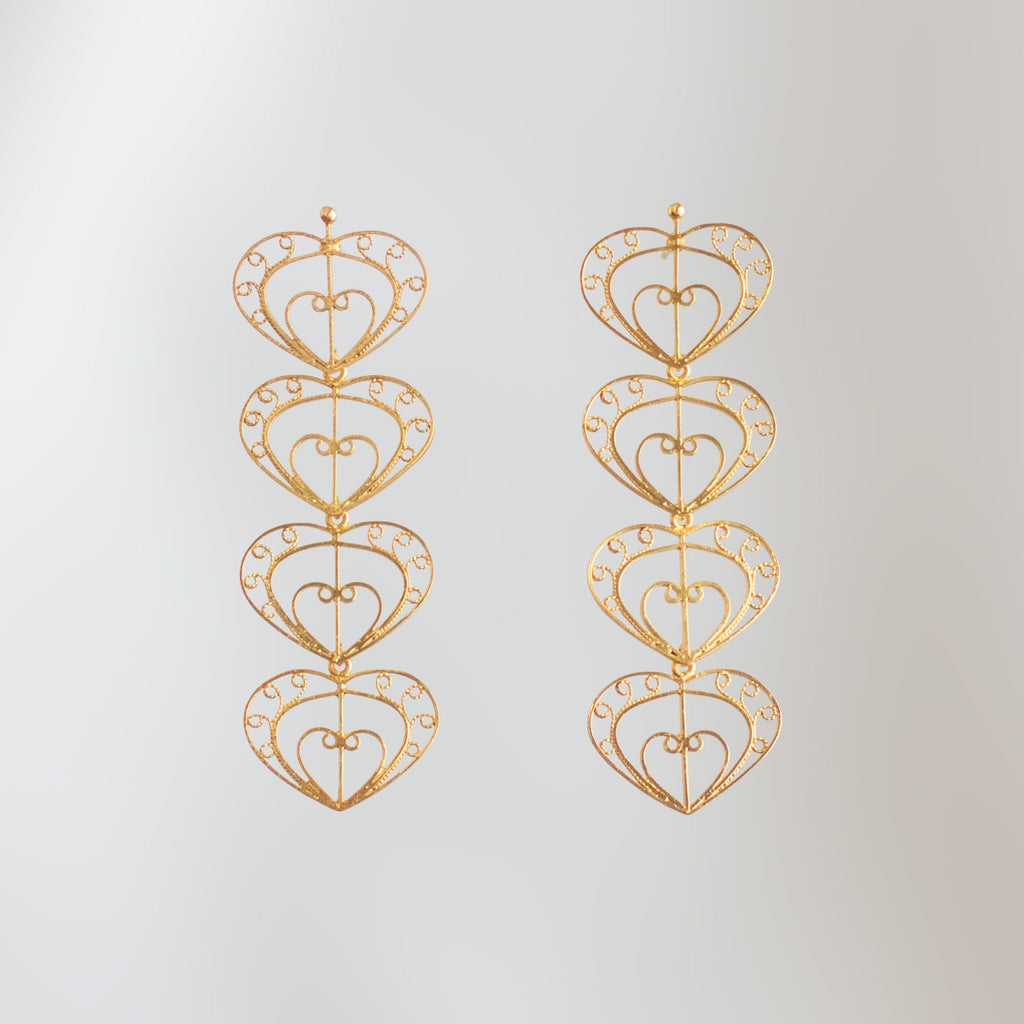 Aretes largos Cuatro Latidos de filigrana momposina dorada con cuatro corazones tejidos.