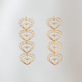 Aretes largos Cuatro Latidos de filigrana momposina dorada con cuatro corazones tejidos.