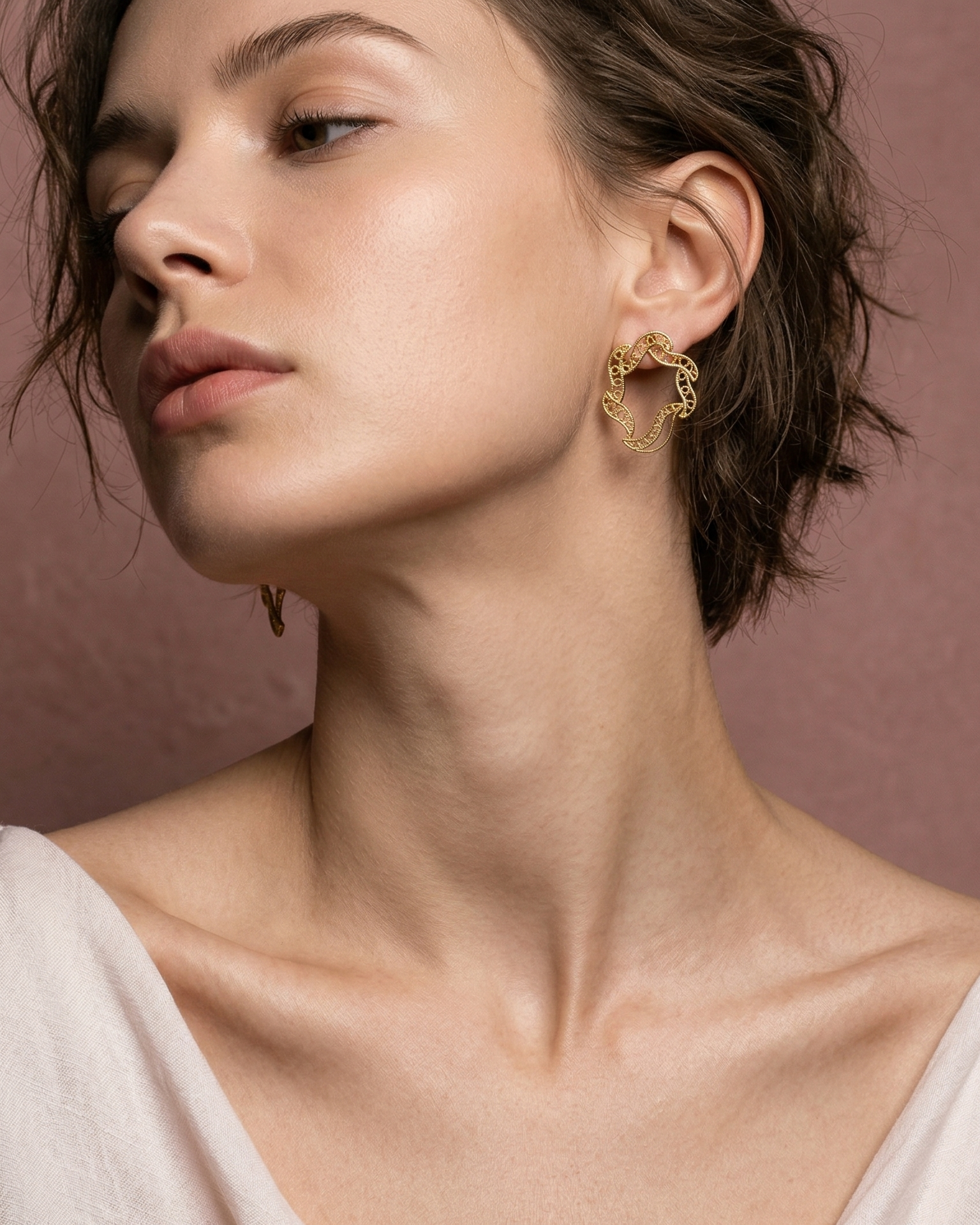 Modelo luciendo los aretes mini Elie de DAILA para un look minimalista y elegante.
