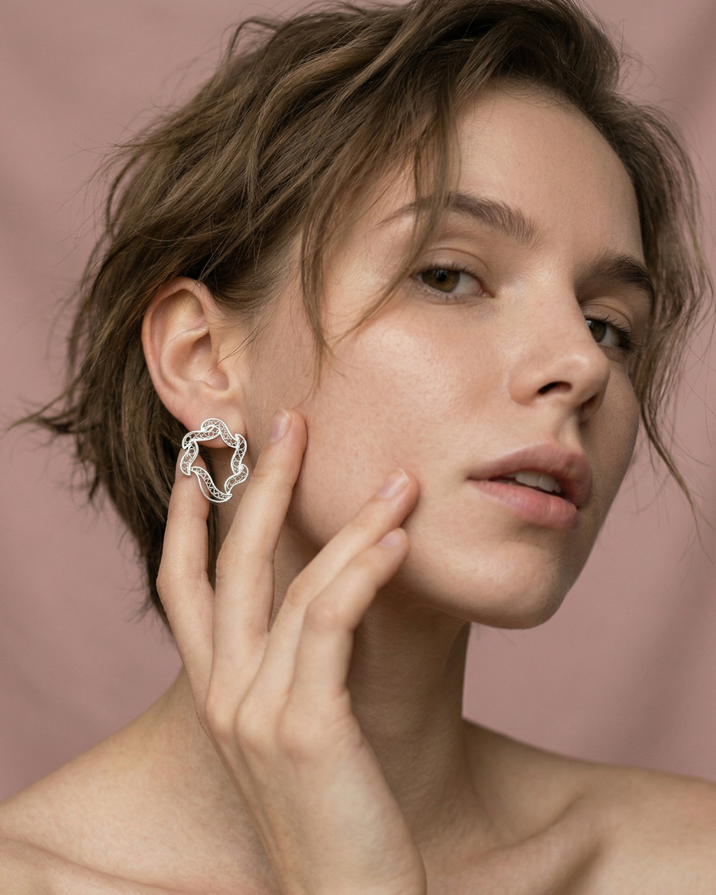 Modelo luciendo los aretes mini Elie de DAILA para un look minimalista y elegante.