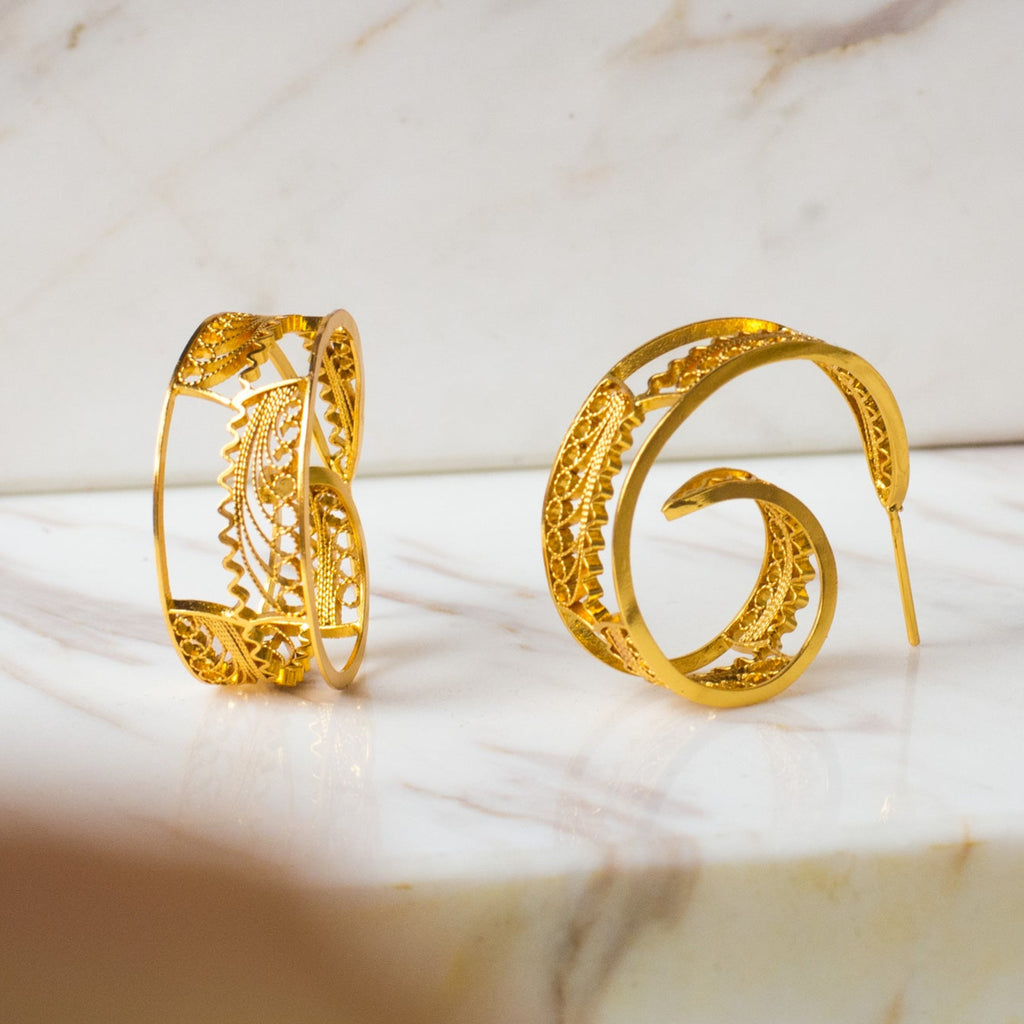 Aretes cangonga o aros en espiral en filigrana momposina elaborados en plata 9.80 con chapado en oro de 24 kilates u oro rosado y protección en laca cataforética. Joyas hechas a mano por artesanos Colombianos.